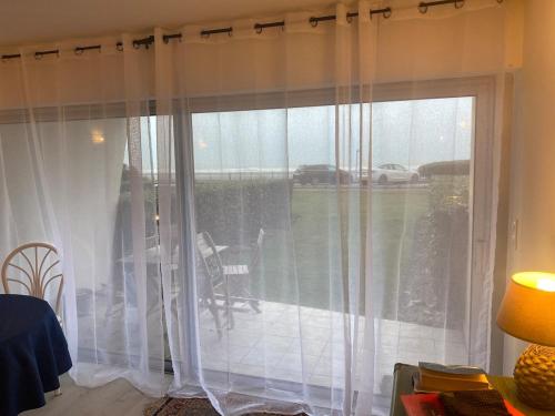 Cette chambre dispose d'une fenêtre avec des rideaux blancs. dans l'établissement Studio Sunshine, à Le Touquet-Paris-Plage