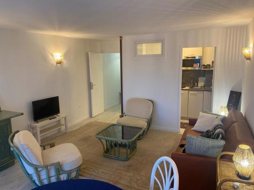 un salon avec un canapé, des chaises et une télévision dans l'établissement Studio Sunshine, à Le Touquet-Paris-Plage