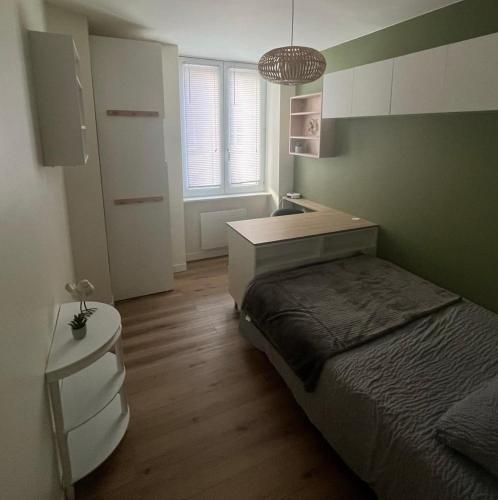 une petite chambre avec un lit et un lavabo dans l'établissement Appartement cosy et raffiné, à Cherbourg en Cotentin