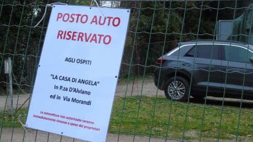 a sign in front of a fence with a car at The Angela's House and large balcony on the square in Todi