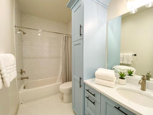 Un baño con lavabo, inodoro y bañera. en The Red Farmhouse, en Garden City