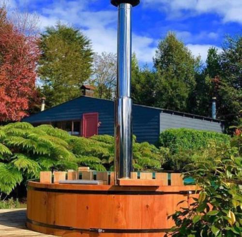a wooden structure with a pole in a yard at Lofts Magnolias in Puerto Varas