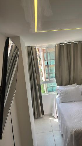 a small bedroom with a bed and a window at Flat - Eco Miragem Centro de Porto de Galinhas in Porto De Galinhas