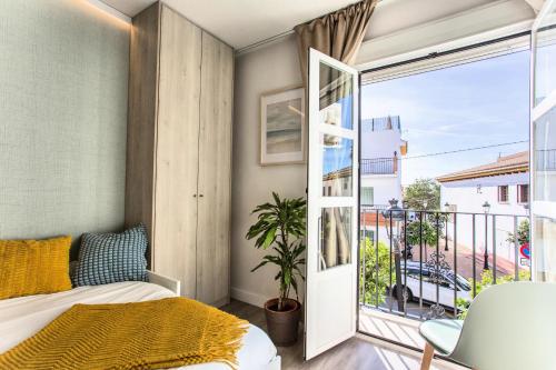 a bedroom with a bed and a large window at Estudio San Juan in Benalmádena