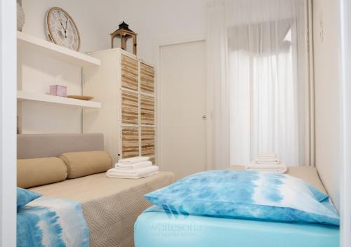a room with a bed and a clock on the wall at WHITE SOFIA - uno sguardo sul mare in Bari