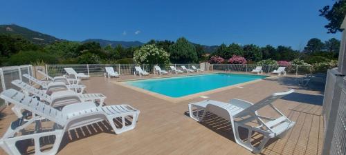 un groupe de chaises longues et une piscine dans l'établissement Villa 