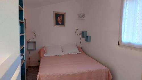 Ce petit lit se trouve dans une chambre blanche dotée d'une fenêtre. dans l'établissement Villa 