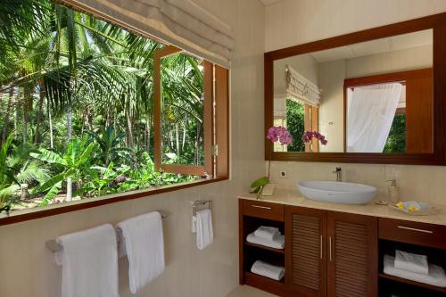 a bathroom with a sink and a large mirror at Villa Tirta Nila by Elite Havens in Candidasa