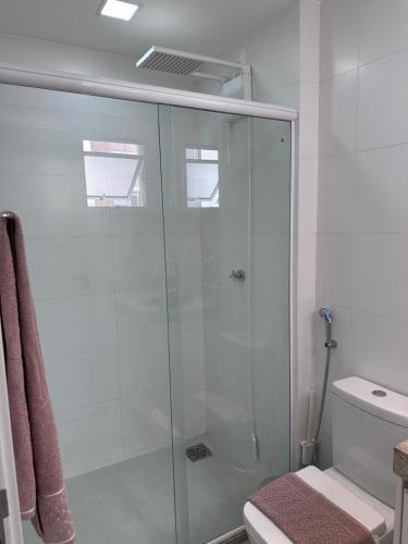 a bathroom with a glass shower with a toilet at Studio 5 Completo Centro com Garagem in Juiz de Fora