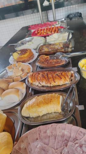 a buffet filled with different types of food on plates at Pousada Recanto do Galo in Santa Cruz Cabrália
