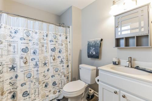 a bathroom with a toilet and a sink and a shower curtain at Oaks of Raleigh II in Raleigh