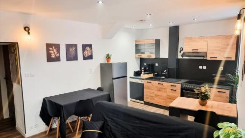 a kitchen and living room with a table and a refrigerator at Bel appartement proche Annecy Aix-les-bains Genève in Seyssel