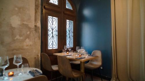 a dining room with two tables and chairs and a window at Hôtel Des Arts-Bastille in Paris