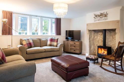 a living room with a couch and a fireplace at Dovestone Cottage in Oldham