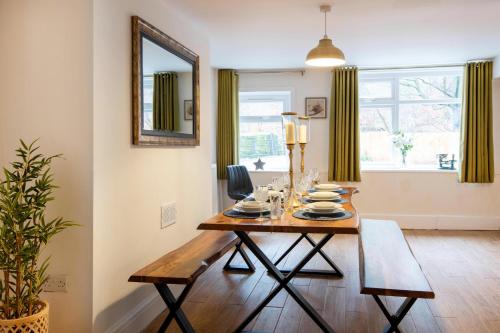a dining room with a table and a mirror at Dovestone Cottage in Oldham