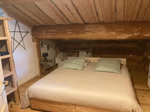 ein großes Bett in einem Zimmer mit Holzdecke in der Unterkunft Magnifique chalet bois pour 16 personnes à 1600m in La Cabanasse