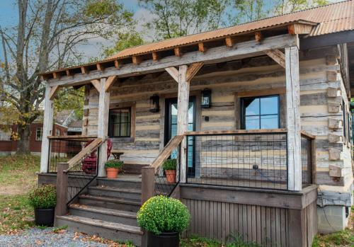 a log cabin with a porch and stairs at Barnwood Village in White Sulphur Springs