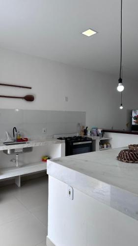 a large white kitchen with a white counter top at Casa George Trancoso in Trancoso