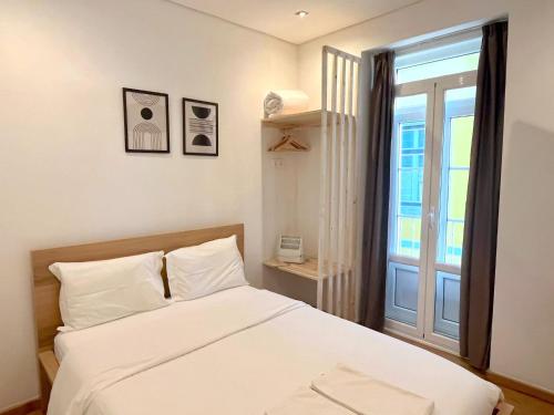 a bedroom with a white bed and a window at Bairro Alto Hostel in Lisbon