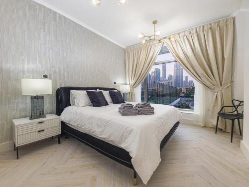a bedroom with a large bed and a large window at Luxury 2-bed Condo Full Burj Khalifa Lights View! in Dubai