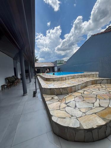 a patio with a swimming pool and a building at Casa Maldonado Morada da Praia 4 suítes in Bertioga