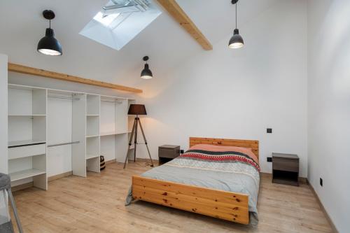 Schlafzimmer mit einem Bett sowie weißen Wänden und Lichtern in der Unterkunft Loft Design Architecte in Roanne