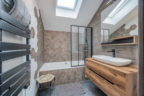 ein Badezimmer mit Waschbecken und Spiegel in der Unterkunft Loft Design Architecte in Roanne