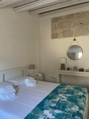 a bedroom with a white bed and a mirror at EGLHOUSE Locazioni brevi in Santa Croce Camerina