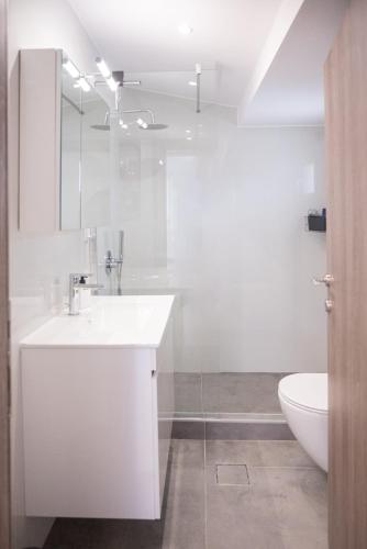 a white bathroom with a sink and a toilet at Sky in Perea