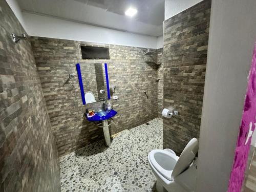 a bathroom with a toilet and a blue sink at Hacienda Dalas Alojamiento Campestre in Villavicencio