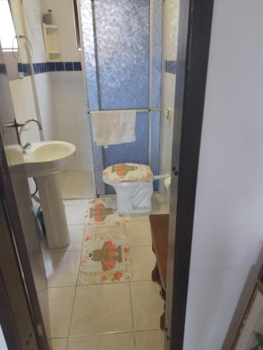 a bathroom with a toilet and a sink at Flat super top in Guaratuba
