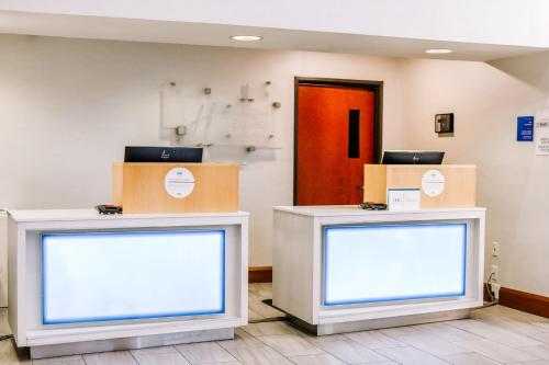two blank monitors in a room with a red door at Holiday Inn Express & Suites Charlottesville - Ruckersville by IHG in Ruckersville
