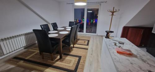 a dining room with a table and black chairs at Cudowny zakątek BIS in Bukwica