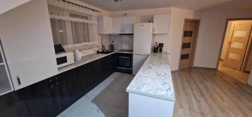 a kitchen with white cabinets and a white refrigerator at Cudowny zakątek BIS in Bukwica