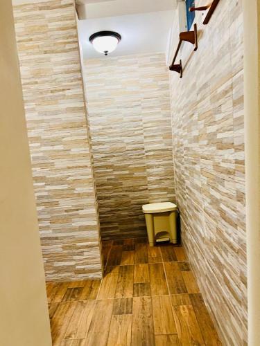 a bathroom with a stone wall and a stool at HOTEL Ecológico BLUEROCK in David