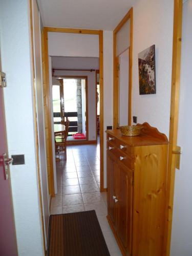 une cuisine avec une armoire en bois et une salle à manger dans l'établissement Valmorel La Belle, skis aux pieds!, à Valmorel