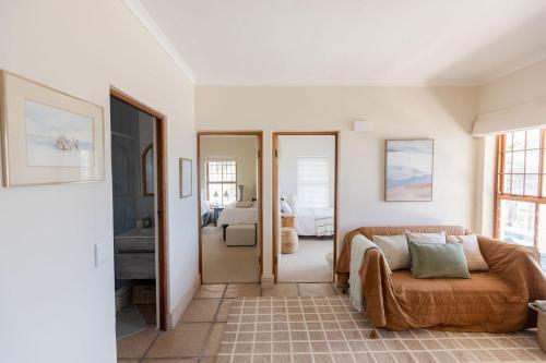 a living room with a couch and a bedroom at SEIA Dream offers stunning ocean views, sunny living spaces, plunge pool and terraces perfect for relaxing, Walk to Simons Town, Seaforth Beach, Boulders Beach penguins, high speed internet, smart TV and back up solar, ideal for families or remote work in Simonʼs Town