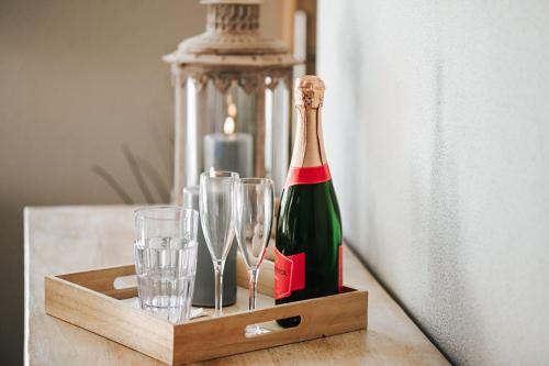 a bottle of champagne and glasses on a table at La Chamallow Cœur d'Artichaud in Dinant