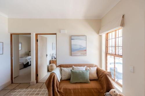 a living room with a couch and a bedroom at SEIA Dream offers stunning ocean views, sunny living spaces, plunge pool and terraces perfect for relaxing, Walk to Simons Town, Seaforth Beach, Boulders Beach penguins, high speed internet, smart TV and back up solar, ideal for families or remote work in Simonʼs Town