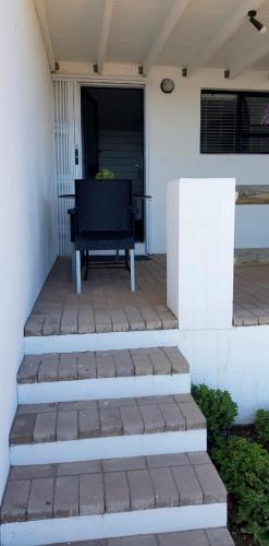 a bench sitting on the porch of a house at View on the Bay 7 Pinta Crescent in St Helena Bay