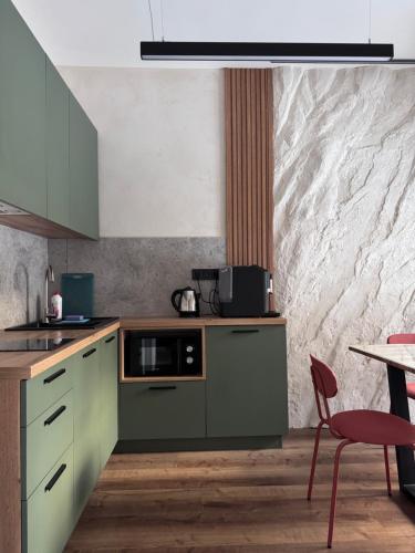 a kitchen with green cabinets and a table at Котедж Gudz in Yaremche