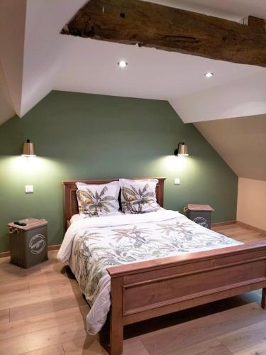 1 dormitorio con 1 cama grande y paredes verdes en Les Chambres de Saint Hilaire, en Saint-Hilaire-Cottes