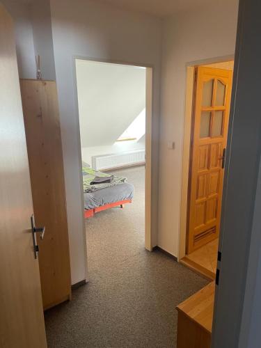 an open door to a bedroom with a bed in a room at Apartmány Penzion Koula in Pec pod Sněžkou