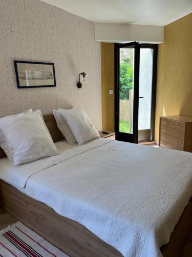 une chambre avec un grand lit blanc avec une fenêtre dans l'établissement Chez Fabienne, tout à pied, à Saint-Malo