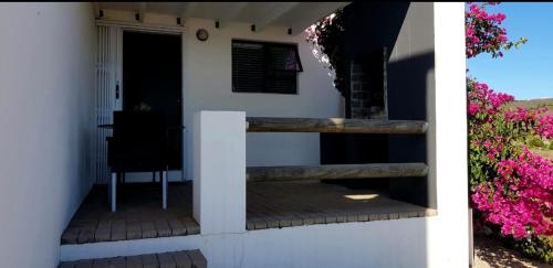 a porch of a house with pink flowers at View on the Bay 7 Pinta Crescent in St Helena Bay