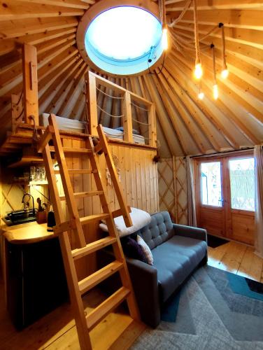 a room with a loft bed in a tree house at Aloha Glamp - okrągłe domki przy rzece - balia i sauna - Energylandia in Zagórnik