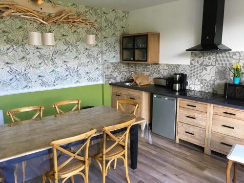 a kitchen with a wooden table and chairs at Les Chambres de Saint Hilaire in Saint-Hilaire-Cottes