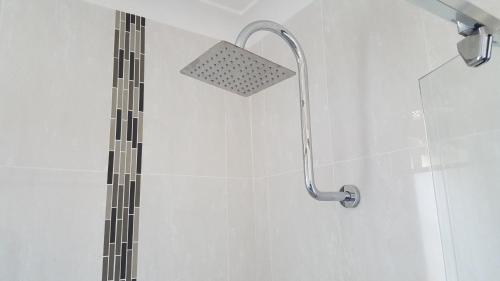 a shower with a shower head in a bathroom at Tuncurry Motor Lodge in Tuncurry