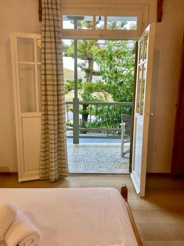 a bedroom with a door open to a balcony at Pansion Episkopi Studios in Skopelos Town