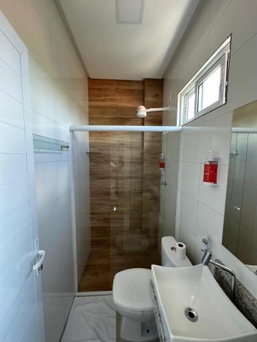 a bathroom with a shower and a toilet and a sink at Hotel Brisas in Bom Jesus da Lapa